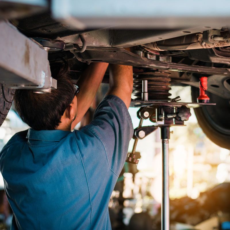 Lexus service technician performing maintenance under a Lexus vehicle