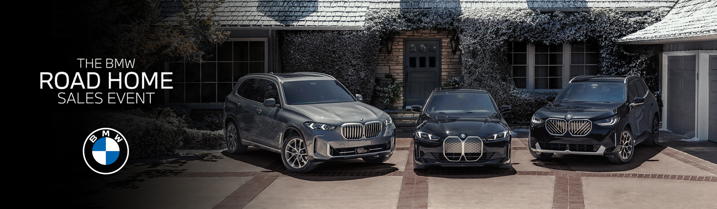 BMW Road Home Sales Event banner featuring a BMW model lineup on display and winter holiday decorations