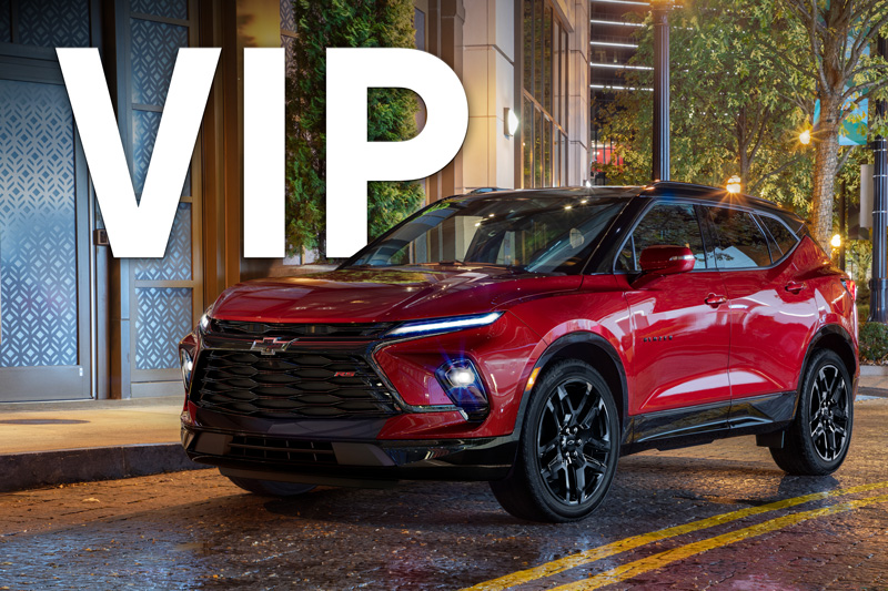 A red Chevrolet Blazer parked on the street at night.