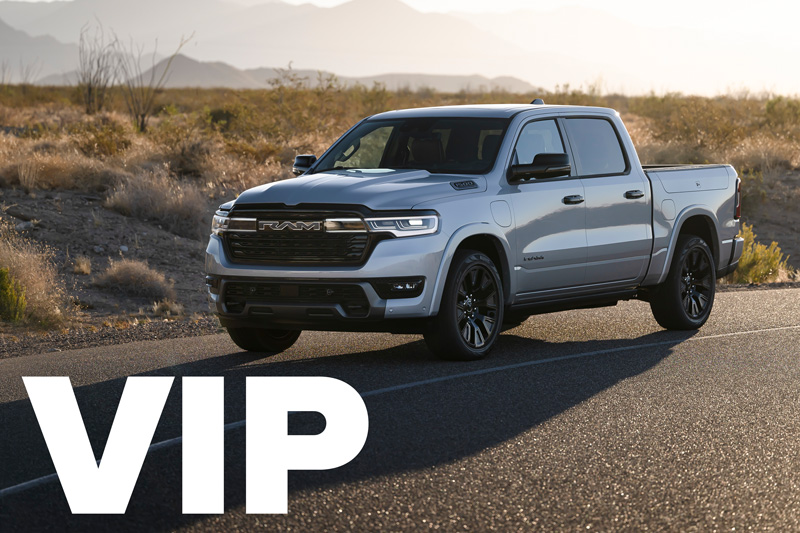 A silver Ram 1500 parked on the side of a road by a desert.