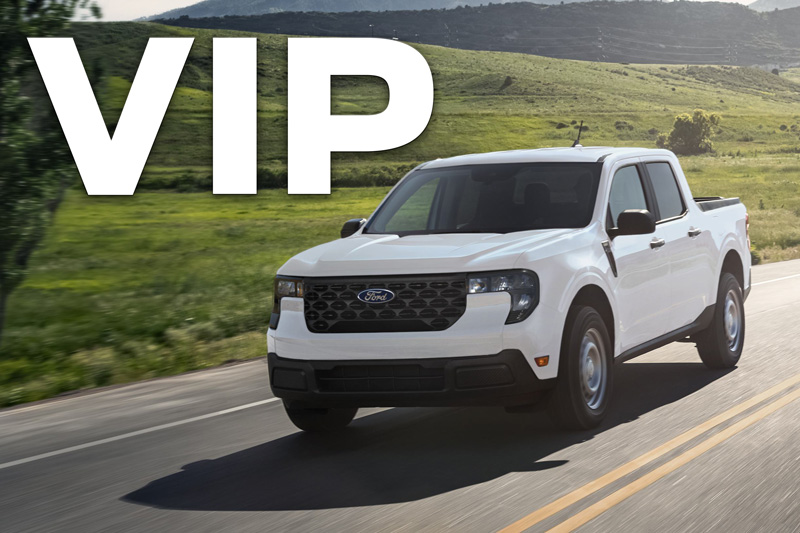 A white Ford Maverick compact pickup truck driving on an open highway.