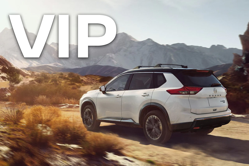 A white Nissan Rogue SUV driving through a desert.