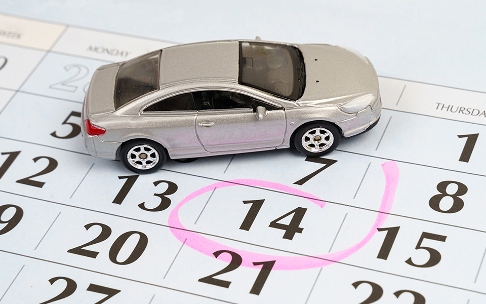 A toy car sitting on top of a calendar with a date circled
