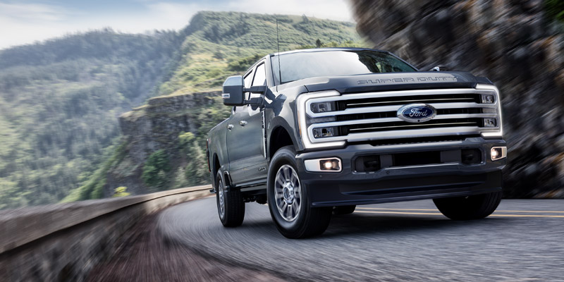 A Ford F-250 driving around the curve up a mountain road