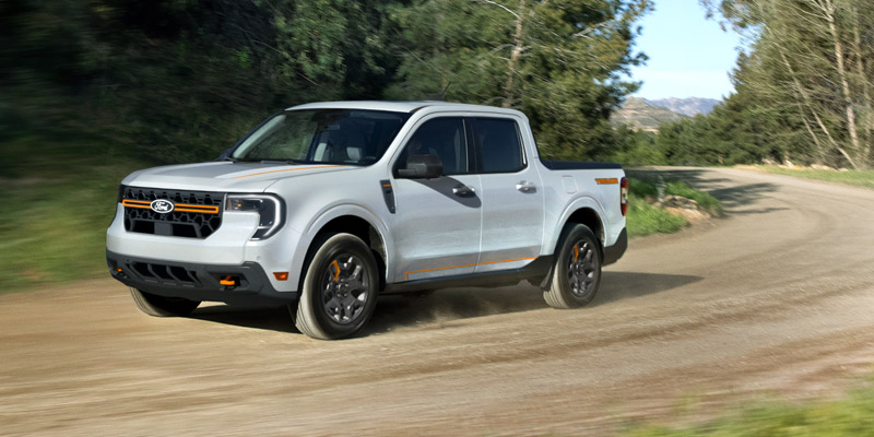 A Ford Maverick driving around the curve on a dirt road