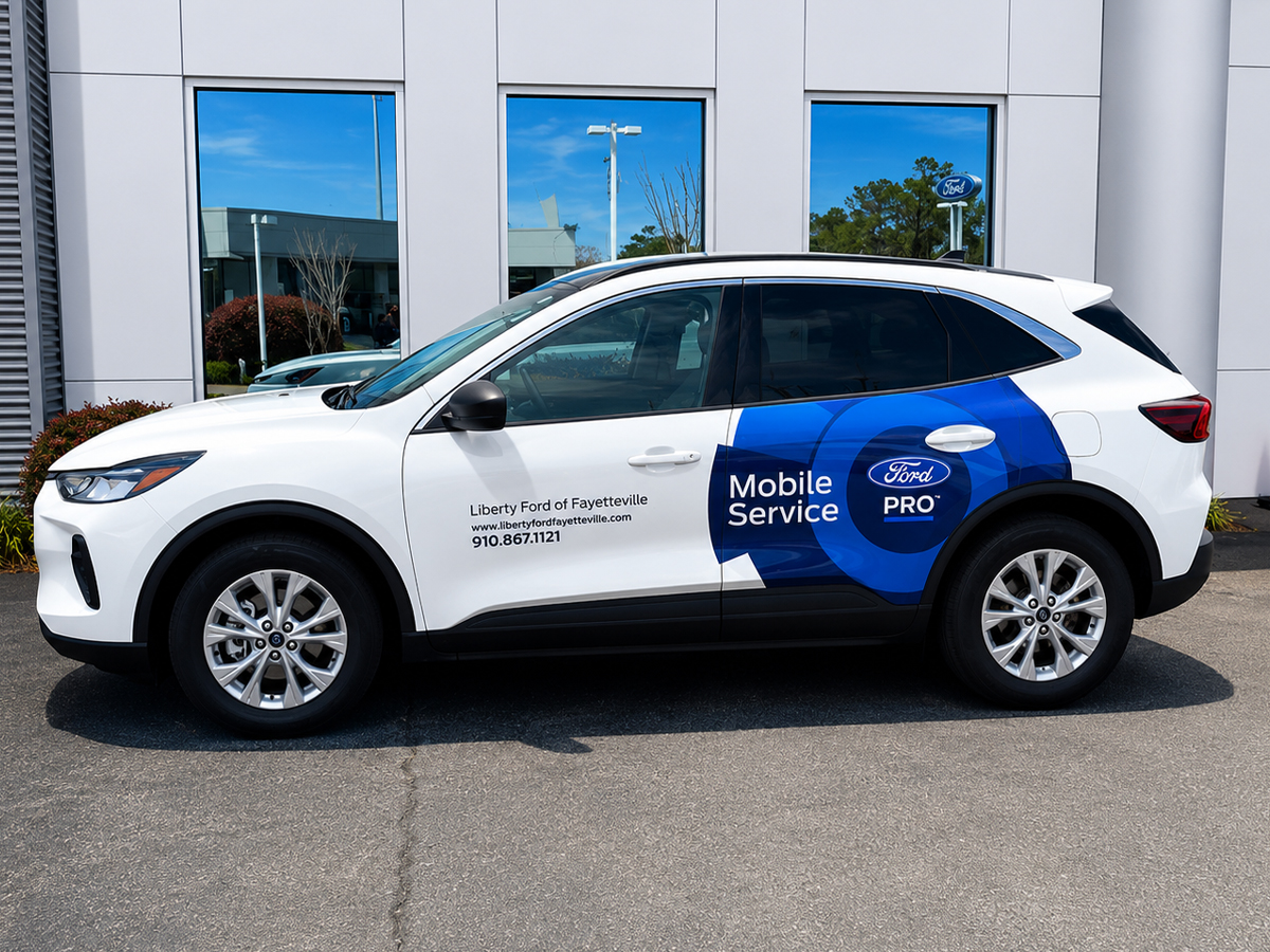 A white Ford Escape wrapped in "Ford Pro Mobile Service" graphics from Liberty Ford of Fayetteville, offering on-site maintenance and recall repairs at your home or workplace.