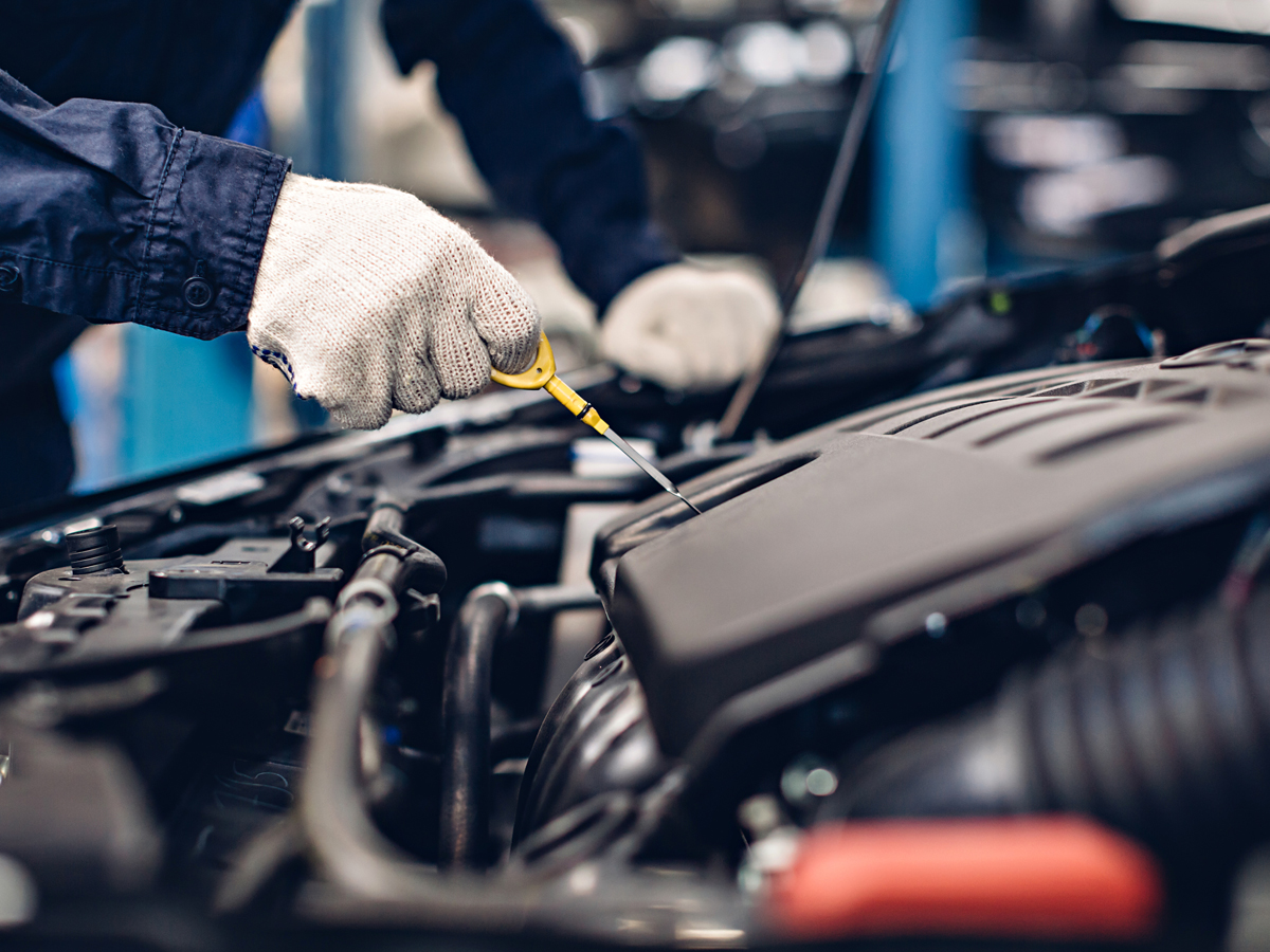 A service technician inspecting a vehicle's engine.