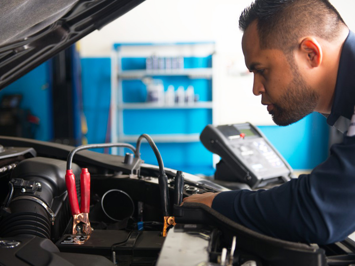 A service technician inspecting a vehicle's engine.