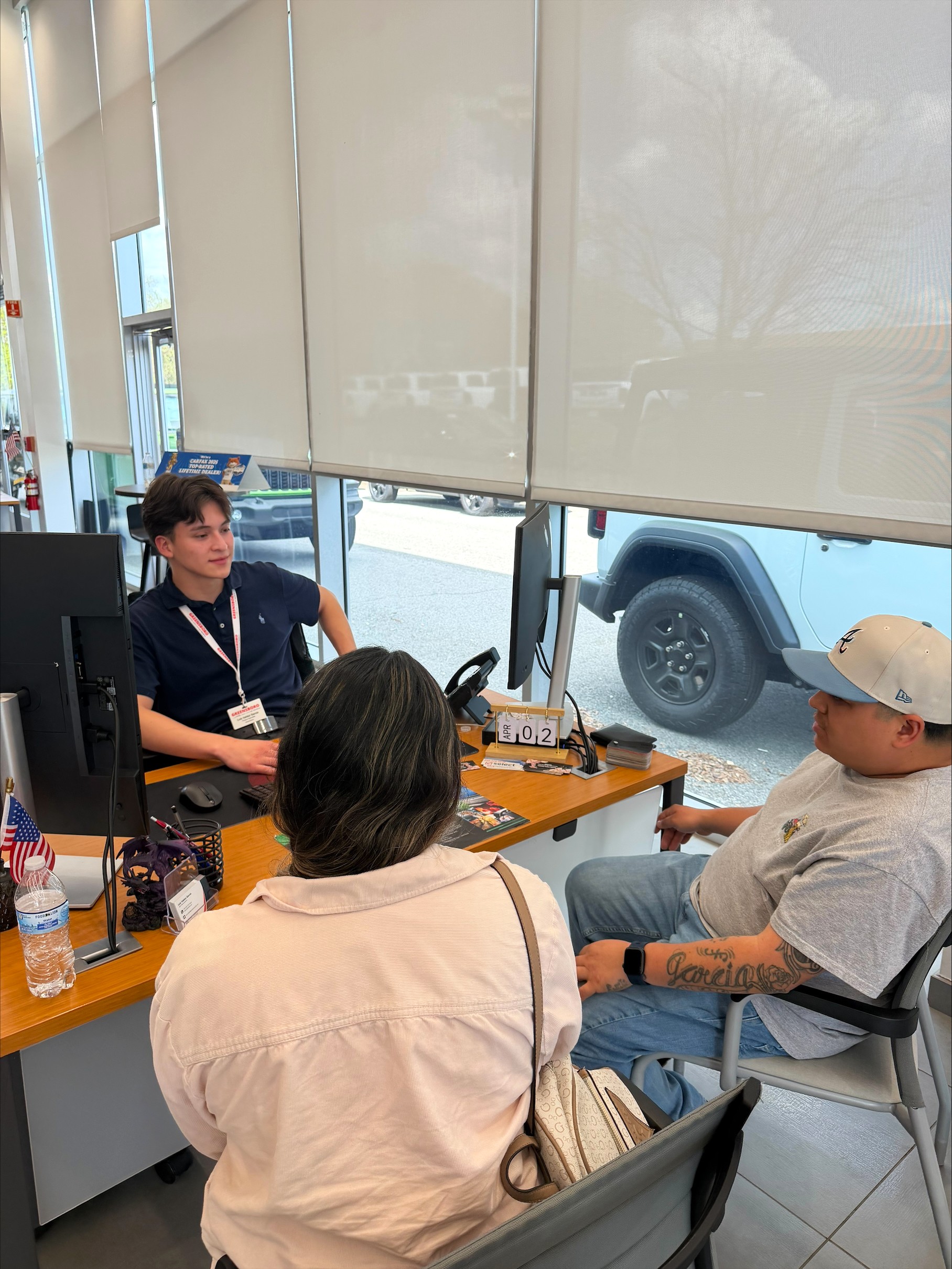 Spanish speaking employee at his desk with clients.