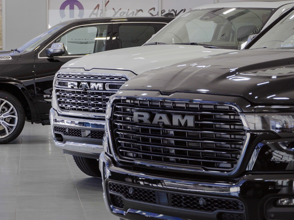 A line-up of Ram pickup trucks inside the dealership.