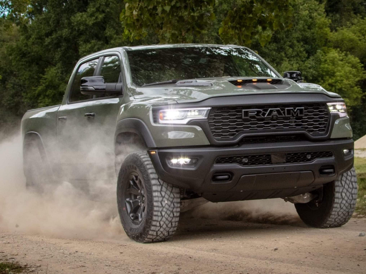 A Ram 1500 pickup truck leaving a trail of dust behind it driving off-road.