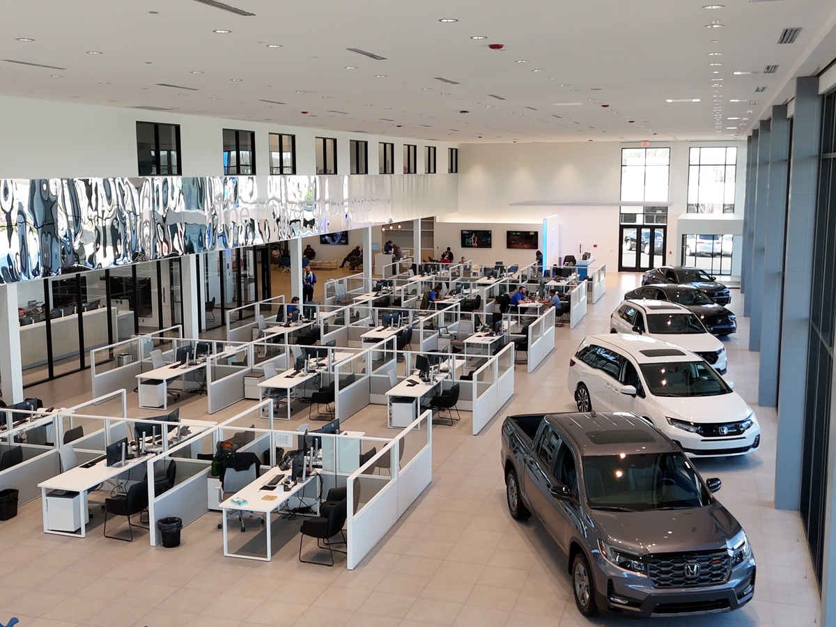 Inside the Greensboro Honda dealership showroom with several vehicles on display.