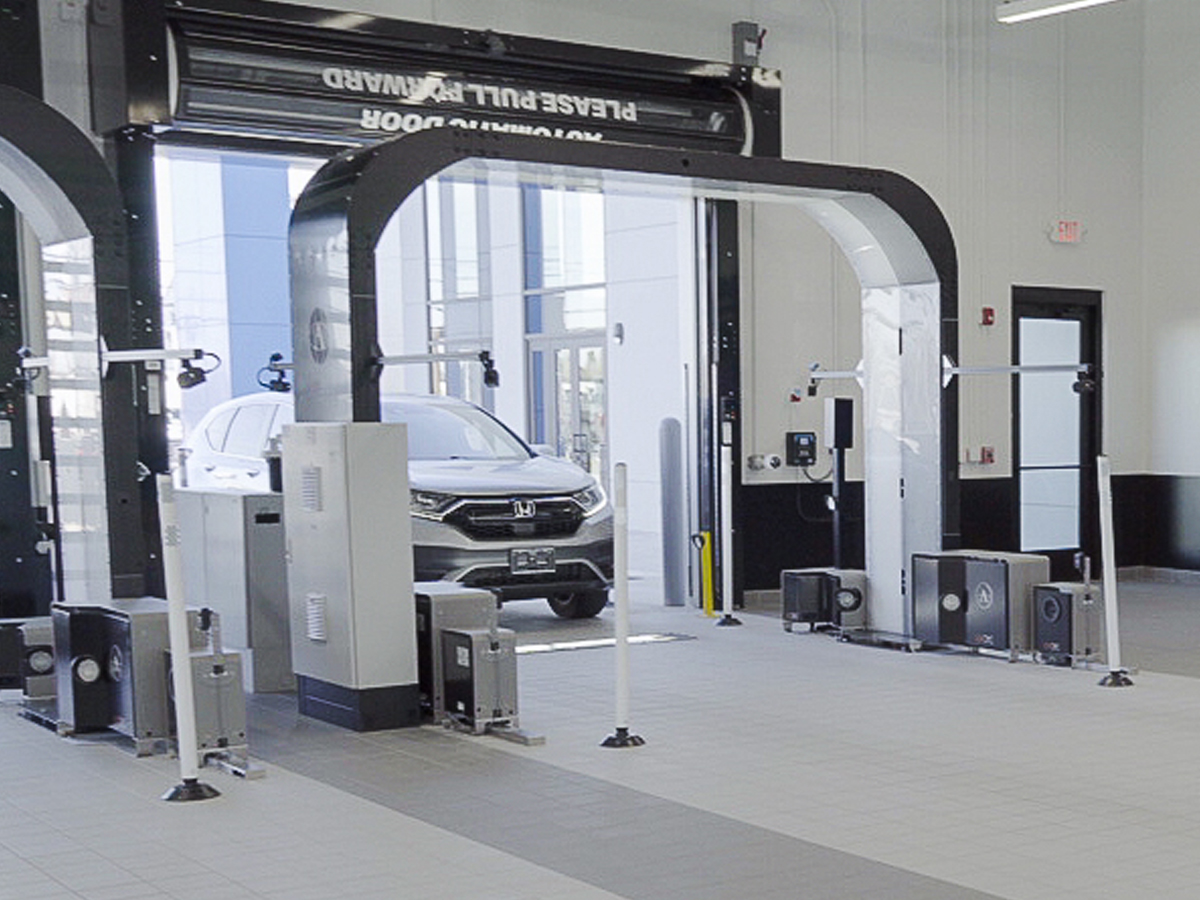 A car driving into the Greensboro Honda service center towards the UVeye automated vehicle inspection system