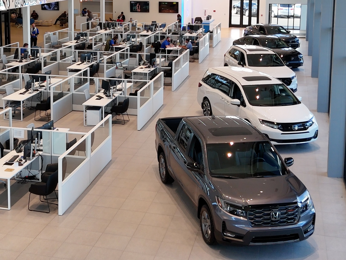 Inside the Greensboro Honda dealershop showroom featuring cubicles and several Honda models on display.