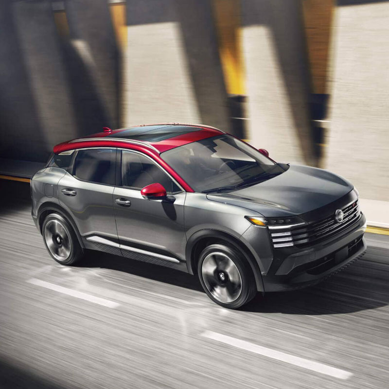 Nissan Kicks driving down a highway in the city.