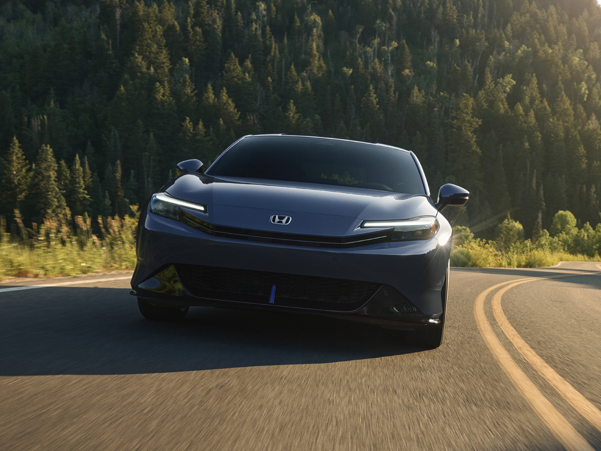 The front view of a black Honda Prelude driving on the highway.