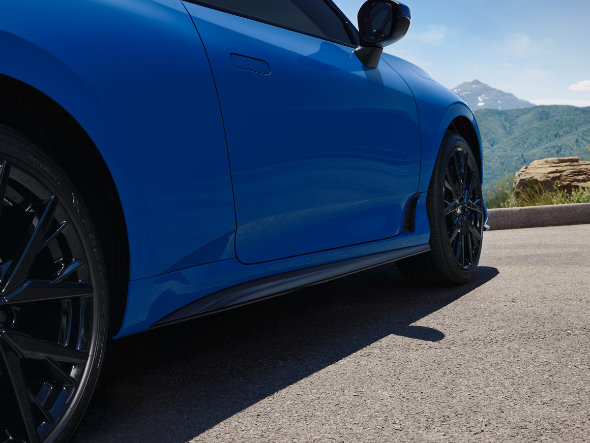 A close-up of the lower half of a blue Honda Prelude.