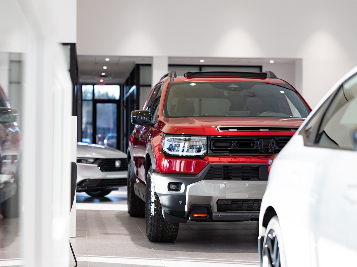 Multiple Honda vehicles parked inside the dealership including a red Honda Passport