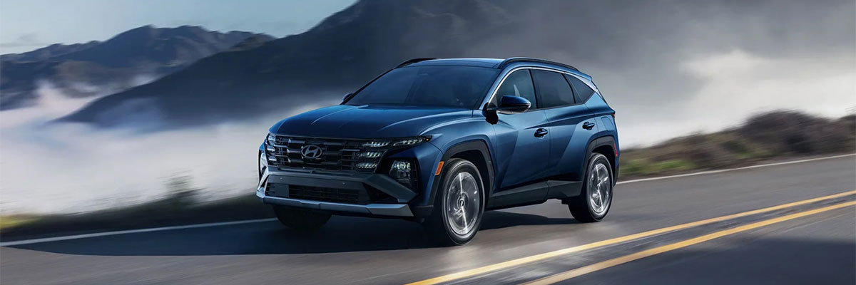 The 2025 Hyundai Tucson driving on a road in the mountains.