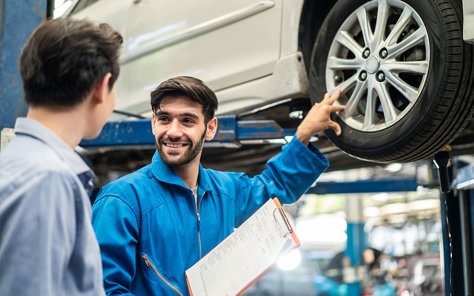 A Hyundai service technician going over the maintenance plan with the vehicle owner.