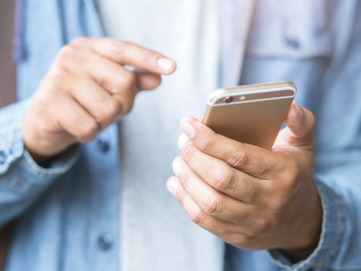 A close-up of someone's hand as they're about to tap their phone's screen