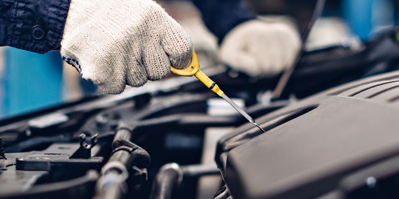 A Honda service technician under the hood of a vehicle
