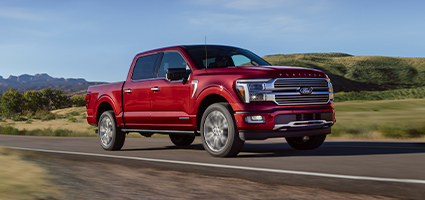 A red Ford F-150 driving on an open road