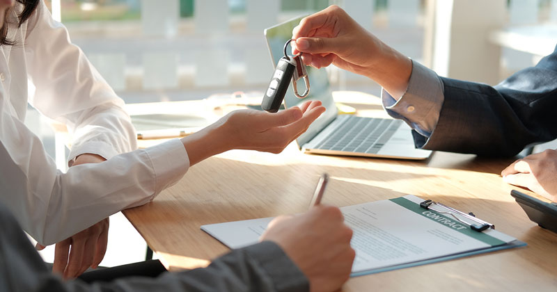 A salesperson handing over Hyundai vehicle keys to a customer