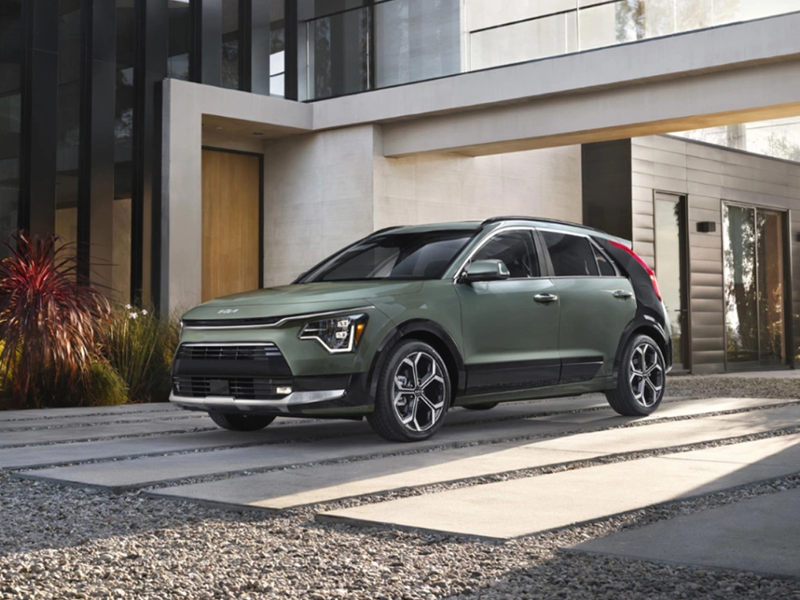 A Kia Niro parked in the driveway of a home