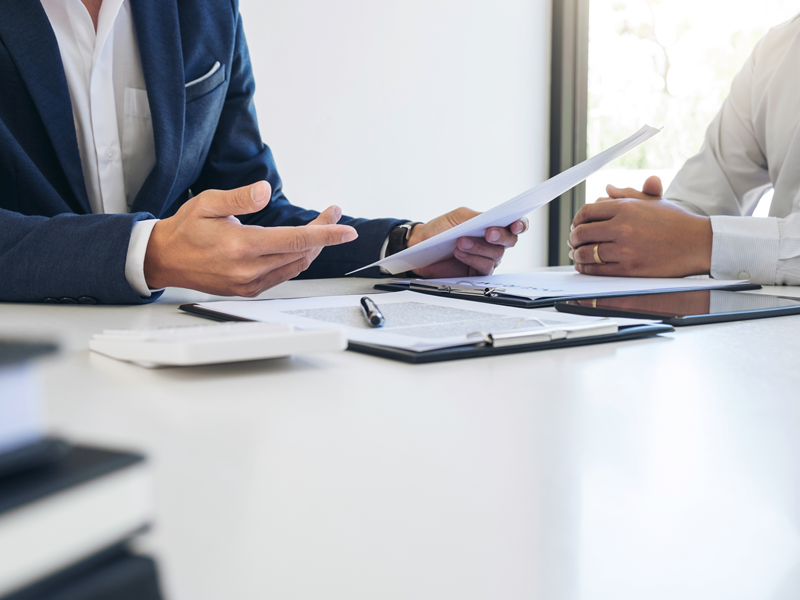 A salesperson and client going over paperwork