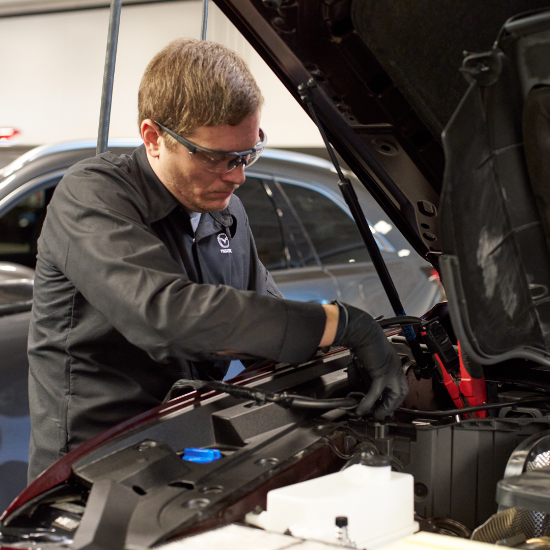 Mazda service technician performing maintenance on a Mazda vehicle in the service center