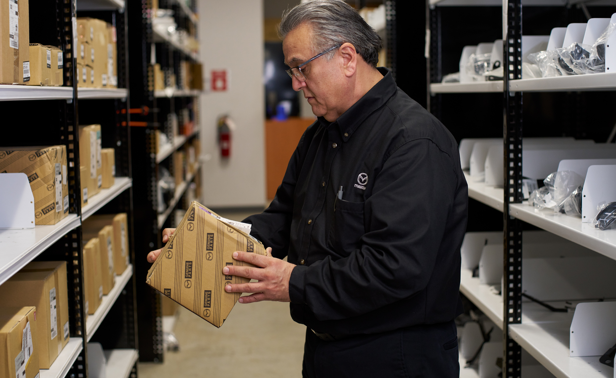 Mazda service technician inspecting genuine Mazda parts