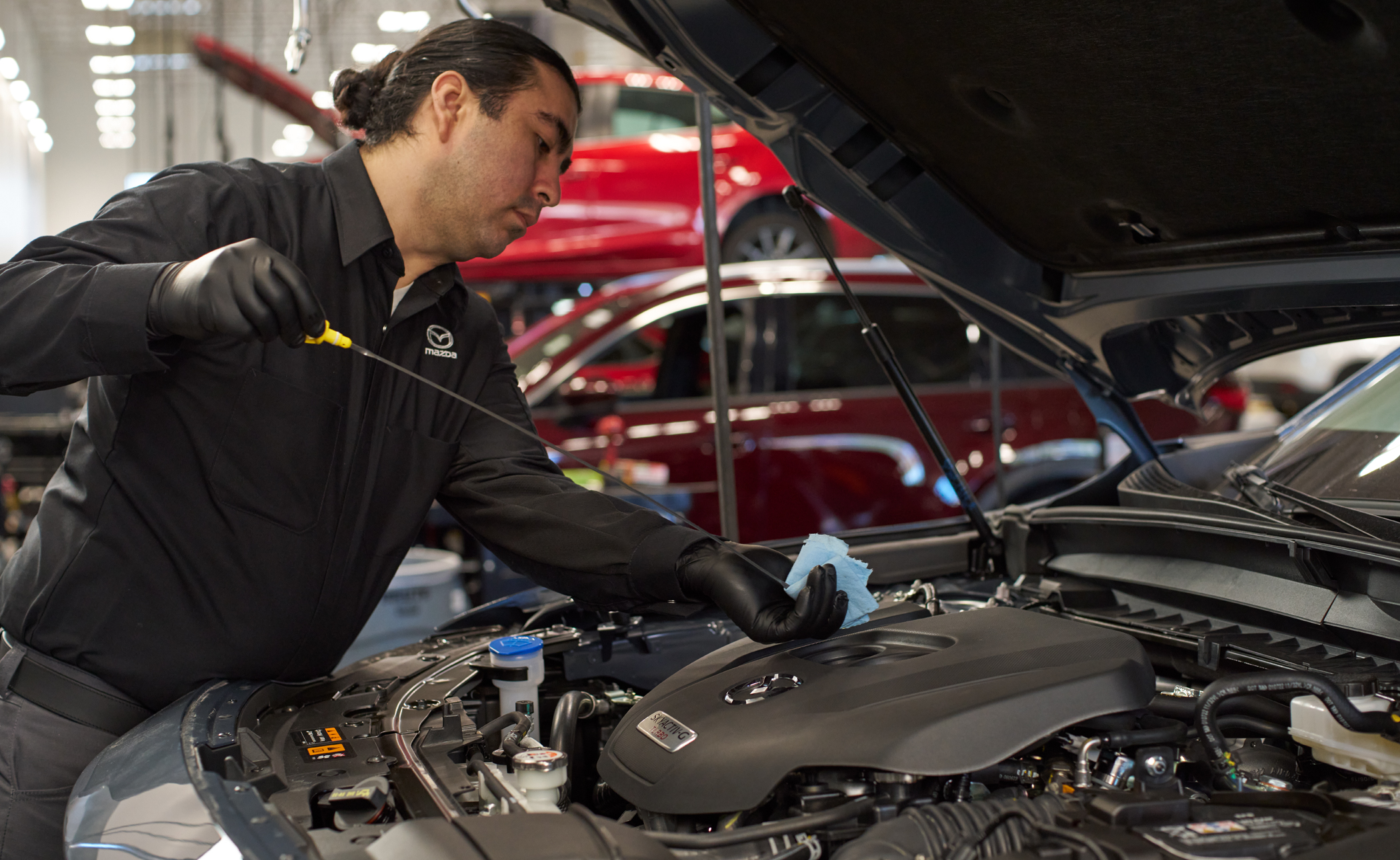 Service technician performing maintenance on a vehicle in the Mazda service center