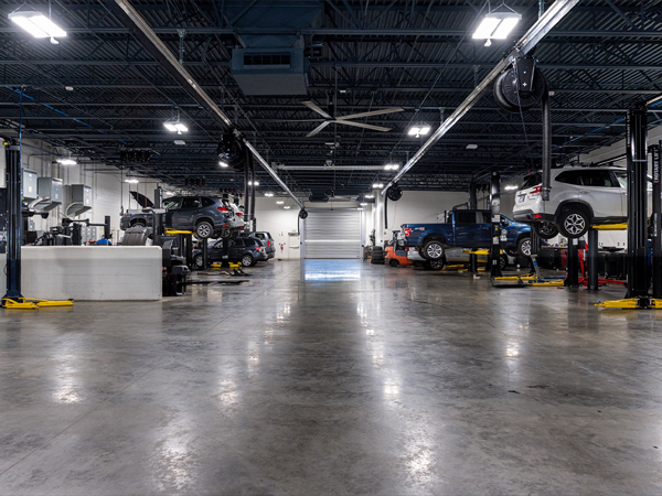 Inside the Wyatt Johnson Subaru service center with multiple vehicles in the car bay