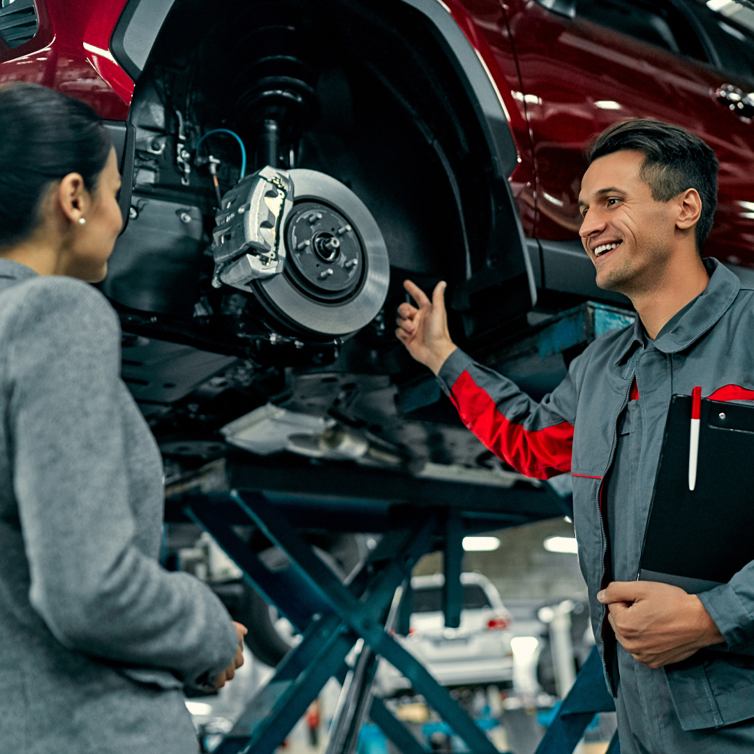 A Toyota service technician showing the car owner their vehicle in the Toyota service center
