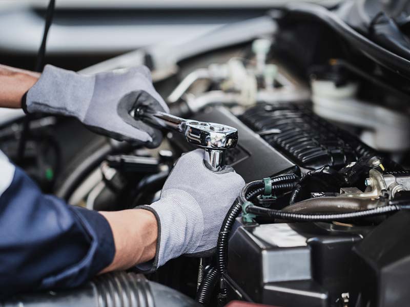 Close-up of a Volkswagen service technician performing service on a vehicle engine