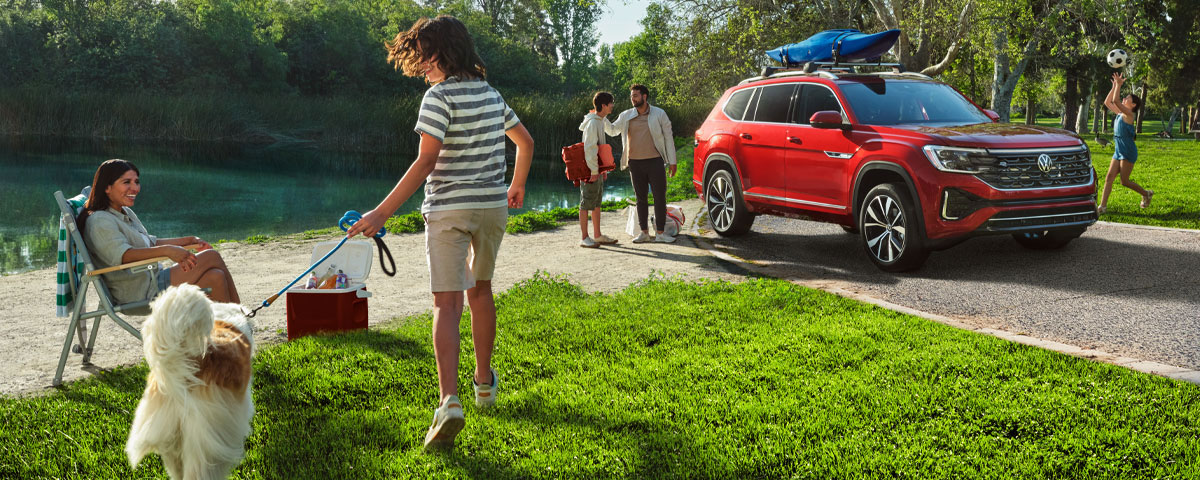 A family unpacking their Volkswagen Atlas at park enjoying recreational activities
