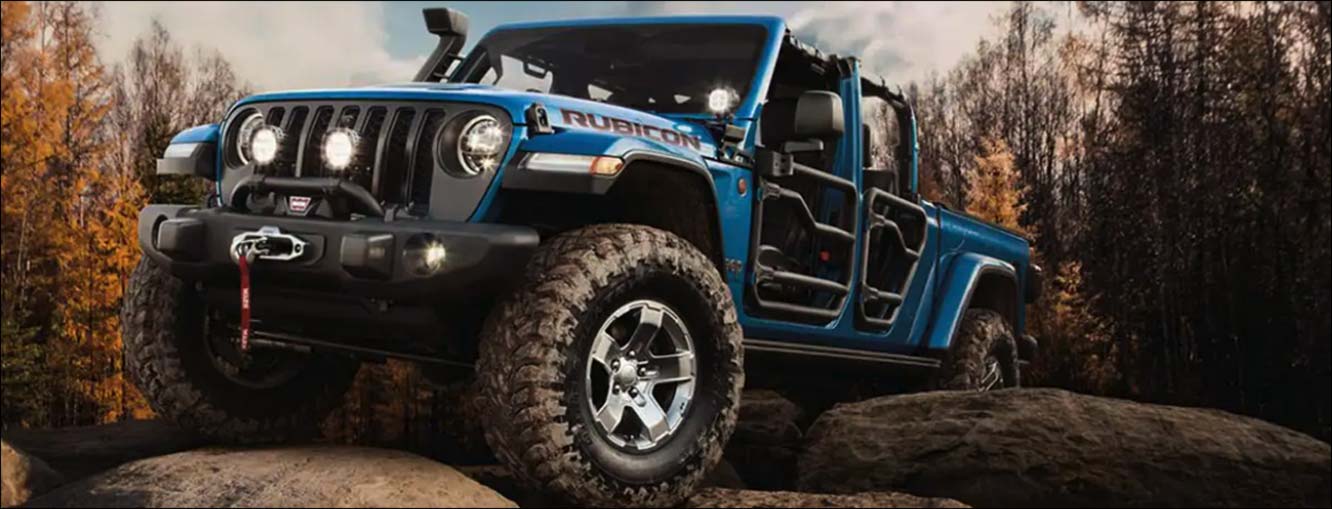 Photo of a blue Jeep Rubicon driving on rough terrain
