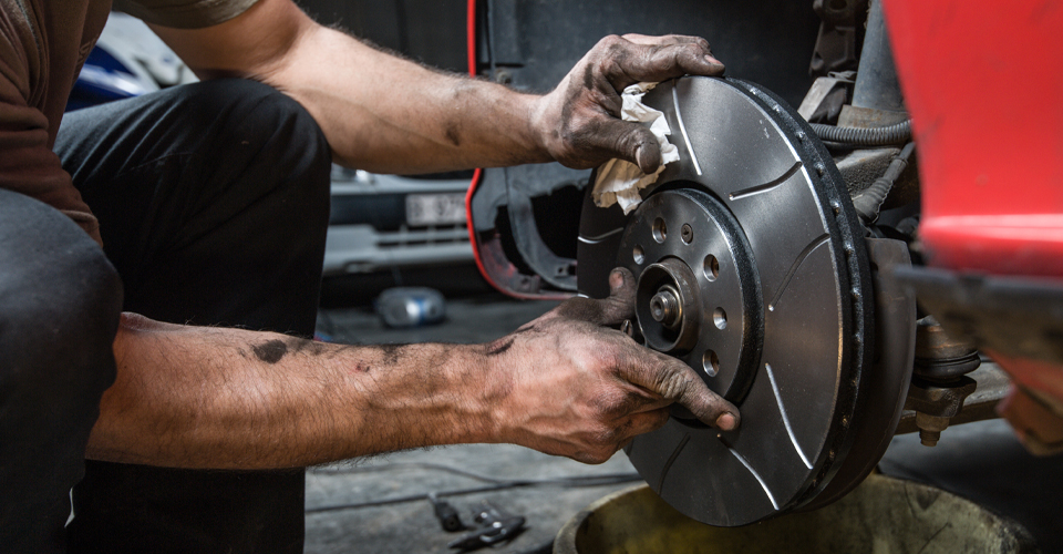 A mechanic finishing installing the brakes on a car
