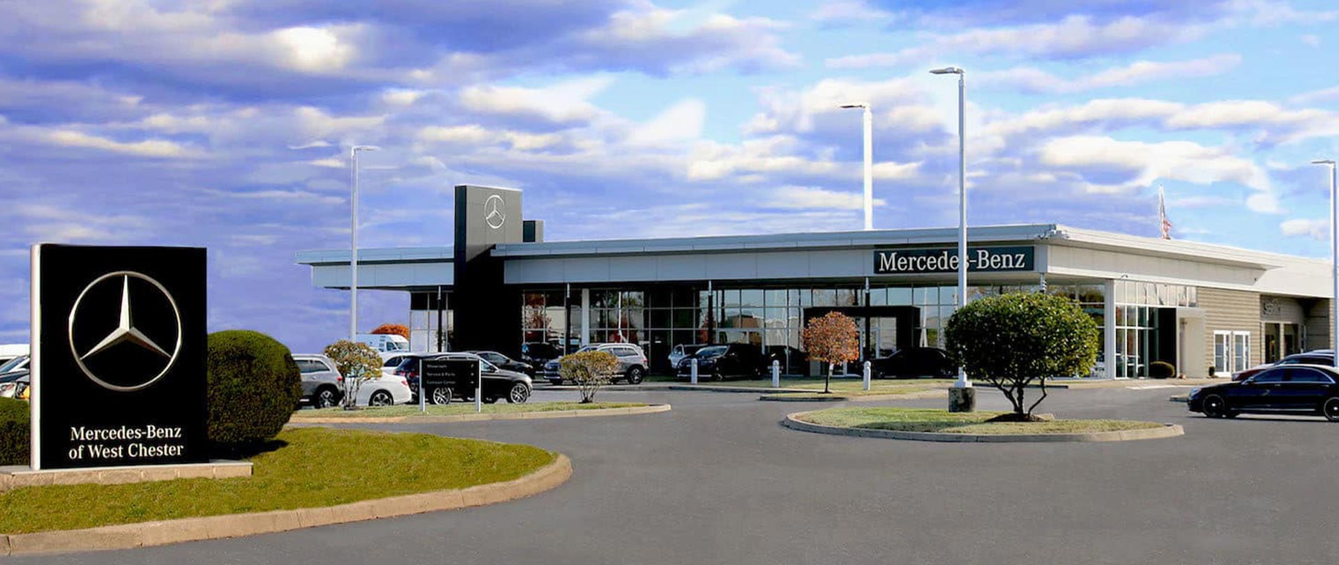 Photograph of the front of the Mercedes-Benz of West Chester dealership and lot.